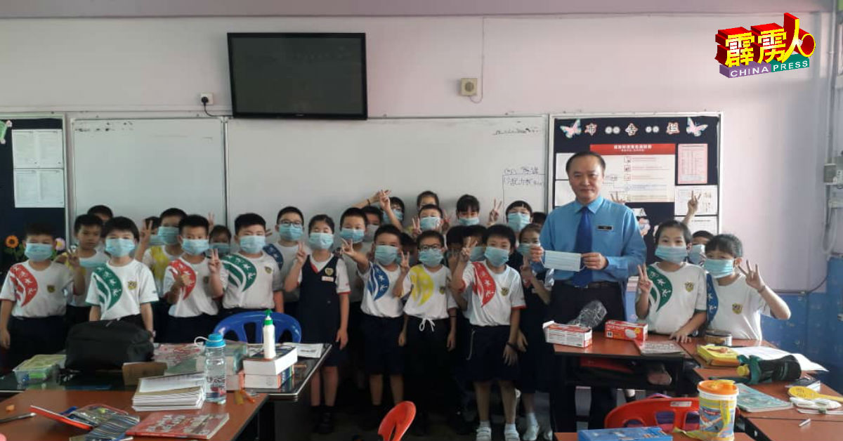 罗俊鹏（右3）教导学生如何正确戴口罩。