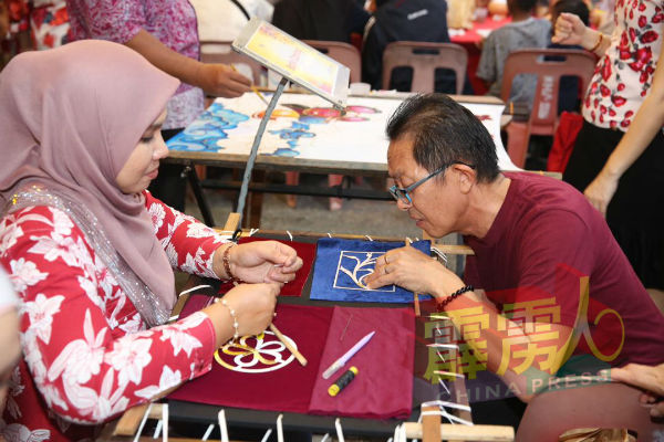 霹雳州新春大团拜，也邀请马来妇女展示马来刺绣，呈华巫文化交流之画面。