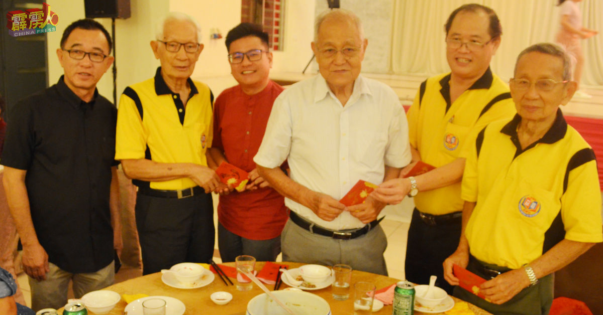 陈利进（右2）和张宇晨（左3）派发敬老红包给70岁以上的社员。
