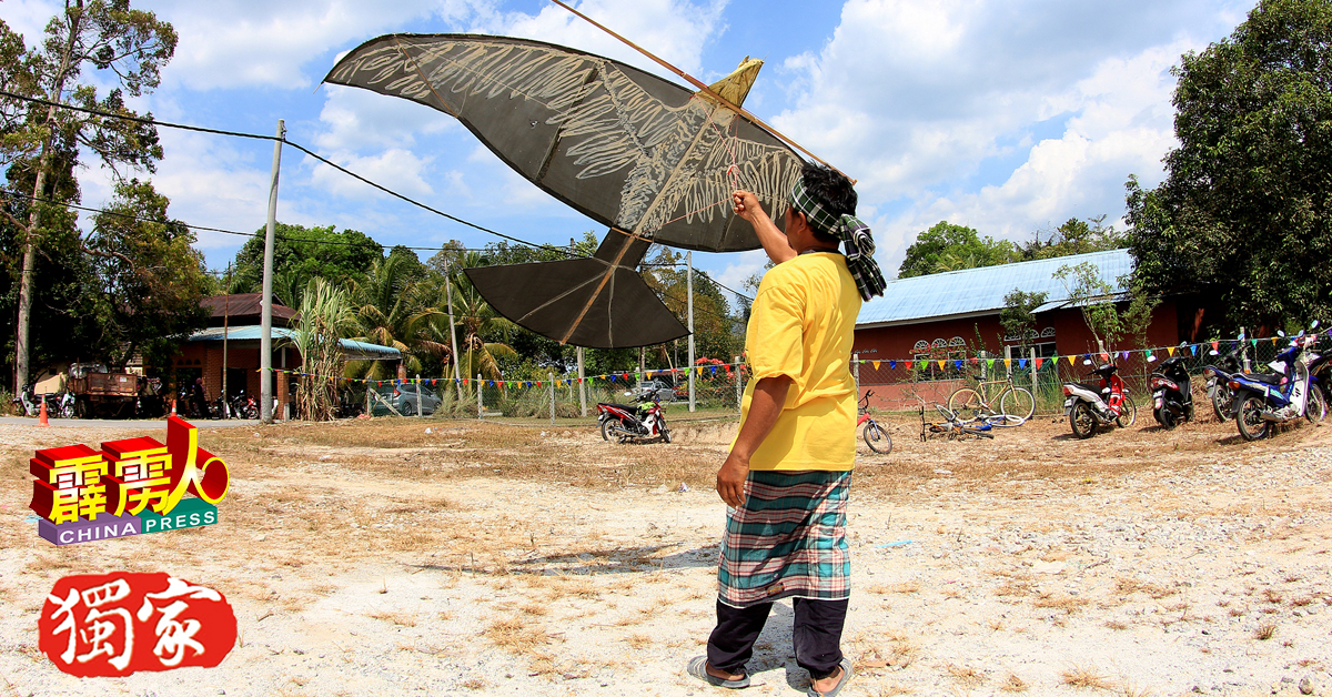 这名传统打扮的参赛者，持着大鸟风筝准备翱翔。