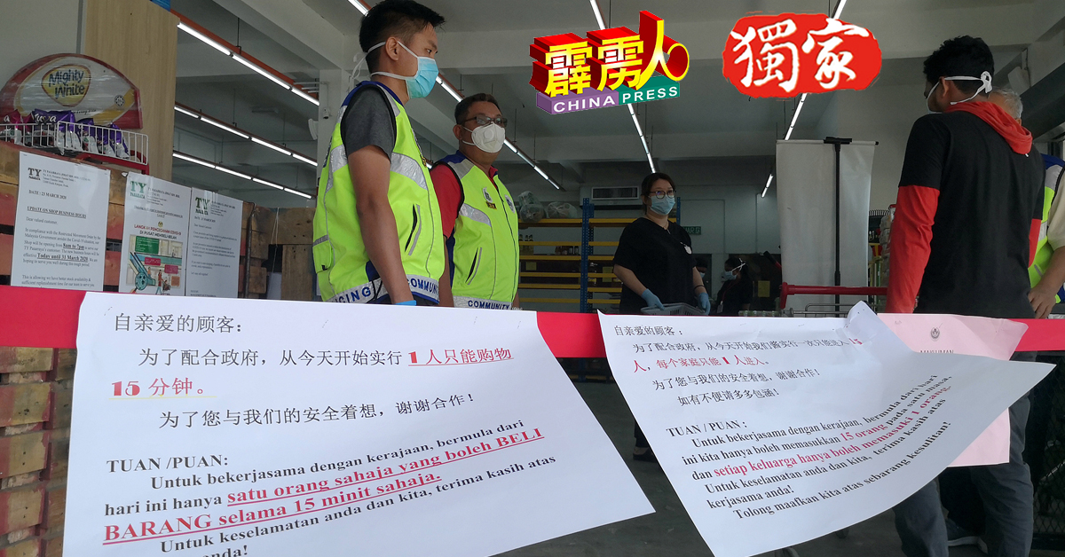 TY超市大门贴满各种中文及国语文容的通告，要求客人为了自己与他人着想，每人只能购物15分钟，而志愿治安公会人员则在门口监督。