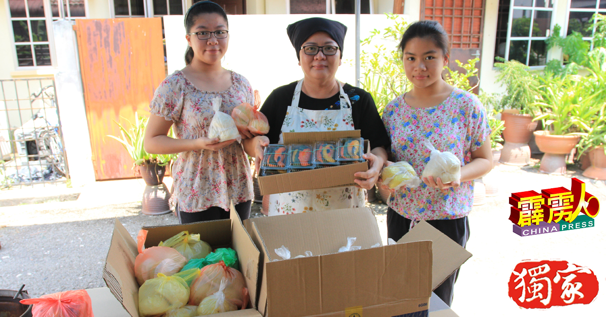 吴金环（中）在大女儿诺莉（左）及幼女爱妮（右）的协助下，花10个小时才完成210粒包子及36件糕点，免费赠送给江沙区的弱势群体。