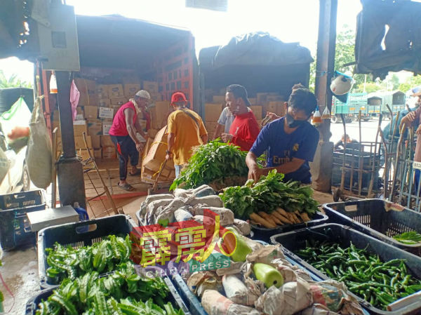 批发菜市场工作人员忙于卸货，以便菜贩尽早取货开业。