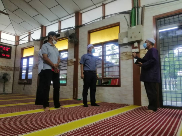 诺阿兹米（右2）一行人巡视清真寺的建筑物情况，并宣布拨款维修。