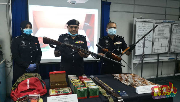 依斯迈（中）与刑事调查主任阿兹曼助理警监（右）及查案官诺哈比扎警长（左），展示起获的枪械与枪弹。