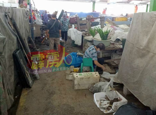 各摊位小贩仍忙于清理摊位的废物。