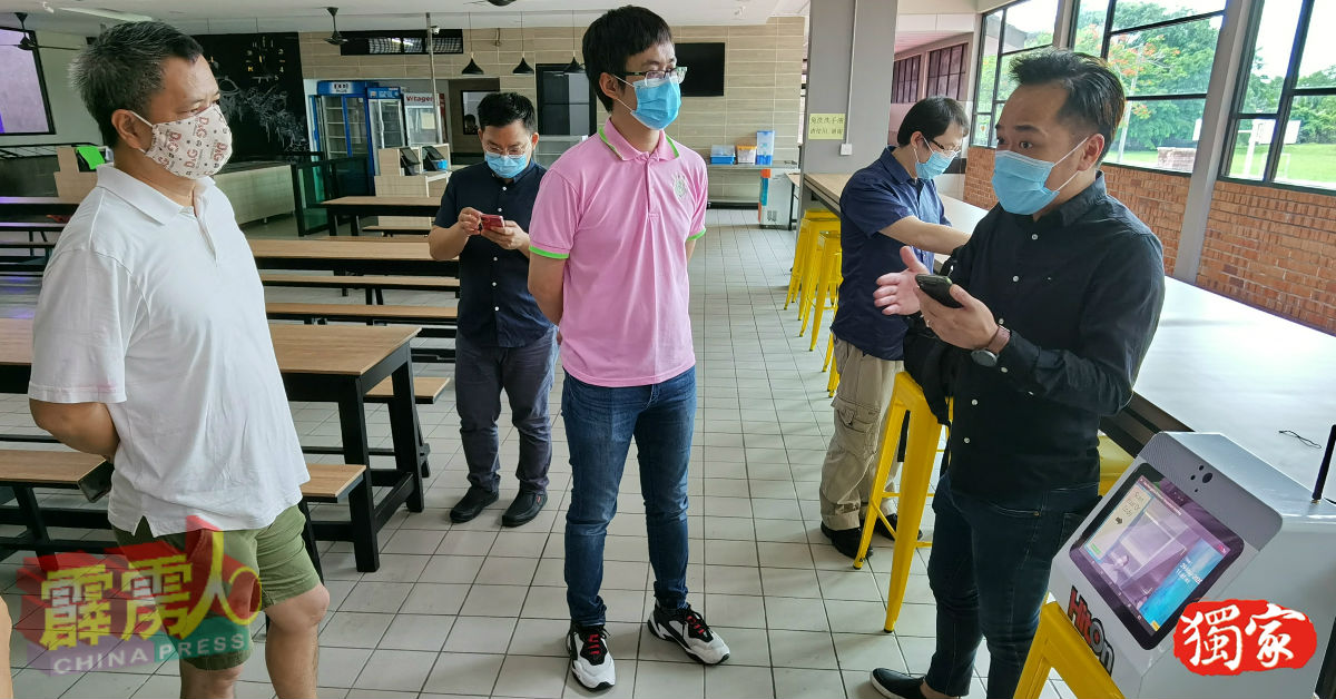 萧清健（前排右起）向李才龙及教师讲解智联体温检测系统的操作。