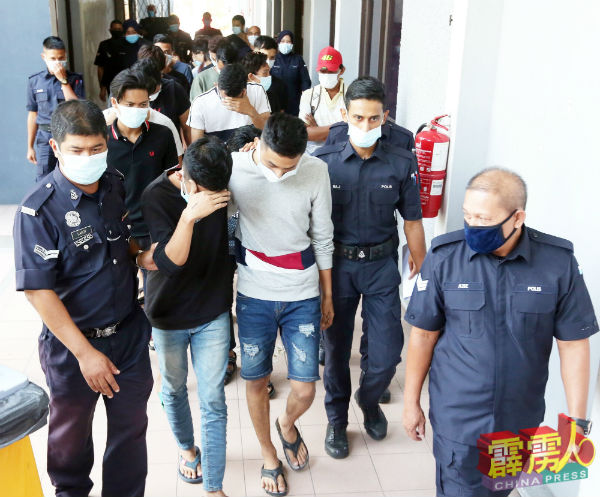 公寓开趴狂欢的14名青年被警方押往法庭面控。