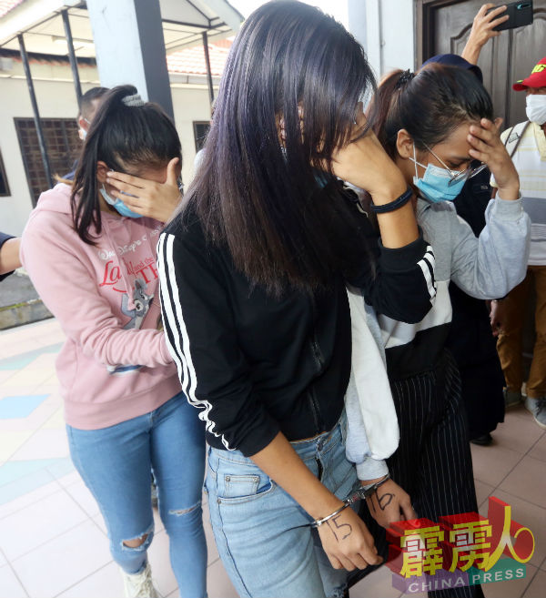 4名女子被押往法庭时以手遮脸。