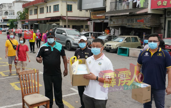 吴佳昌（右起）、邱文传、何伟铭及吉里达仁行走于狮尾多处人群较多的地点，向居民呼吁注意住家单位及店面的卫生环境。