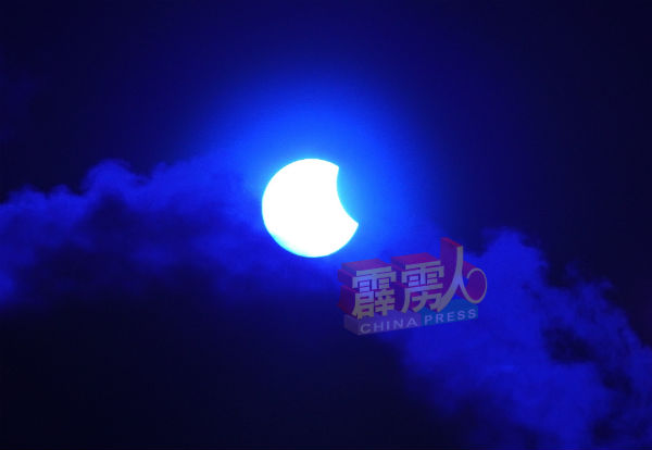 摄于4时06分的怡保日偏食，月亮的影子渐渐离开太阳。