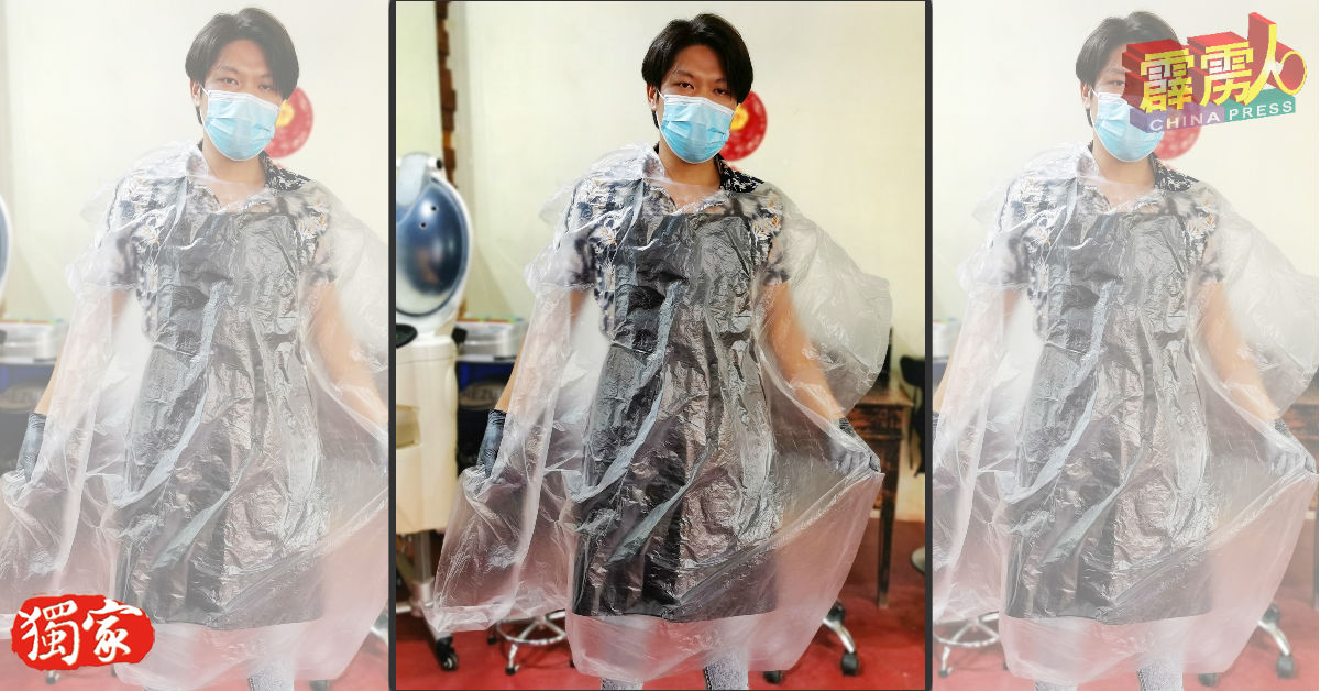 郭宝胜展示顾客于理髮时需穿上的即丢式围裙。