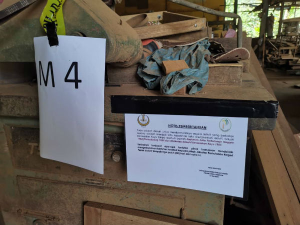 霹雳州森林局在查封的工厂处，贴上相关通告。