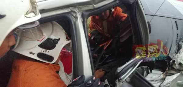 消拯人员合作将受伤的女乘客救出车外，准备让救护车送往医院。