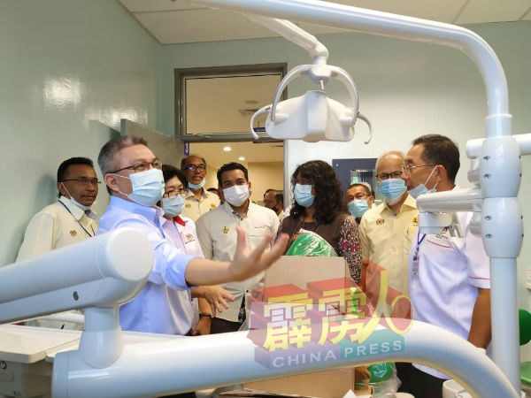 阿汉峇峇（左）参观牙医室，吸取牙医汇报牙科仪器设备；左2为陈丽敏及陈超明（右）。