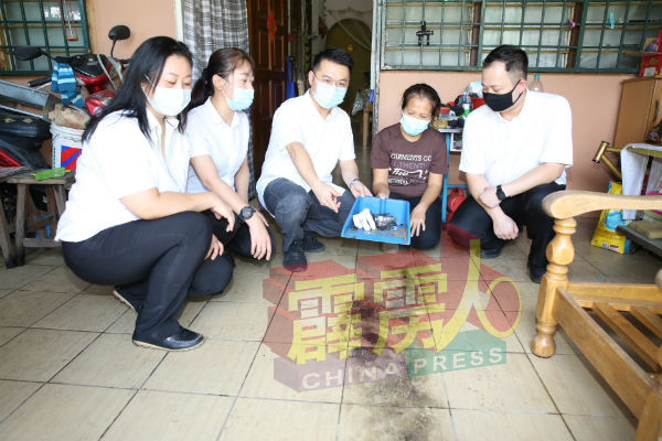 妮莉（右2起）向刘国南指出，阿窿往住家庭院处抛汽油弹，地上还留有被火烧过的痕迹。左起为陈枫溦、张接莉及胡永勤。