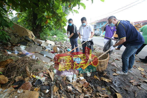 众人分工合作，清除路旁的垃圾堆，以防止蚊虫滋长。