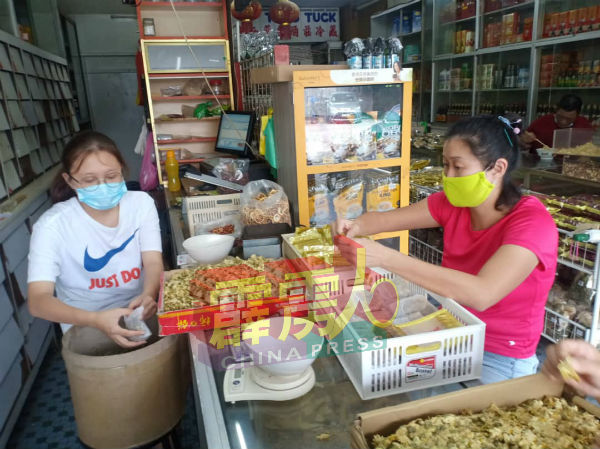 配合市场需求，工作人员忙于包装凉茶包。