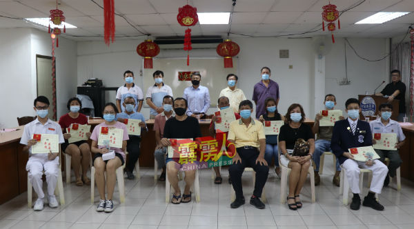 马杰顺（站者左起）、黄永进、蔡尚国、连兴泉、梁锦胜与获颁奖励金的学生与家长合影。
