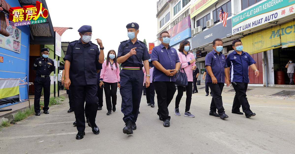 吴文恭（左2）与奥马峇迪（左）巡视江沙商店时，讲述防疫工作的安排。
