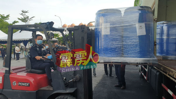 吴文恭用起重机将一桶桶毒品移上罗厘，以便运往森州销毁。