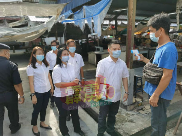 刘国南（右2起）及队员在巡视巴剎时进行验体温。