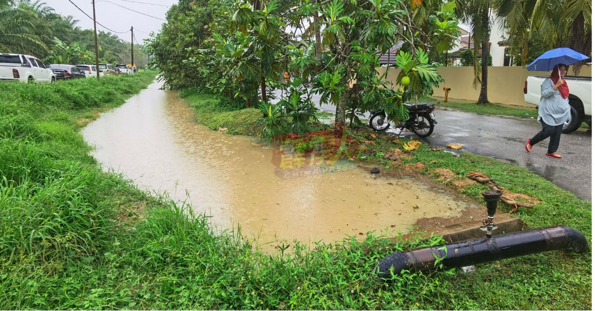 阿曼达迈花园的排水道积水高涨不退，民众已陆续将轿车泊在路边。