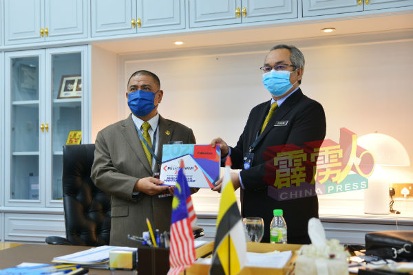 沙拉尼（左）在霹雳州财政司拿督祖拉兹兰手中接过2021年霹雳州财政预算案。
