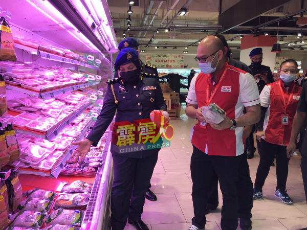 朵蒂尔阿兹琳娜（左）向阿伦（右）了解该超市的各种货品情况。