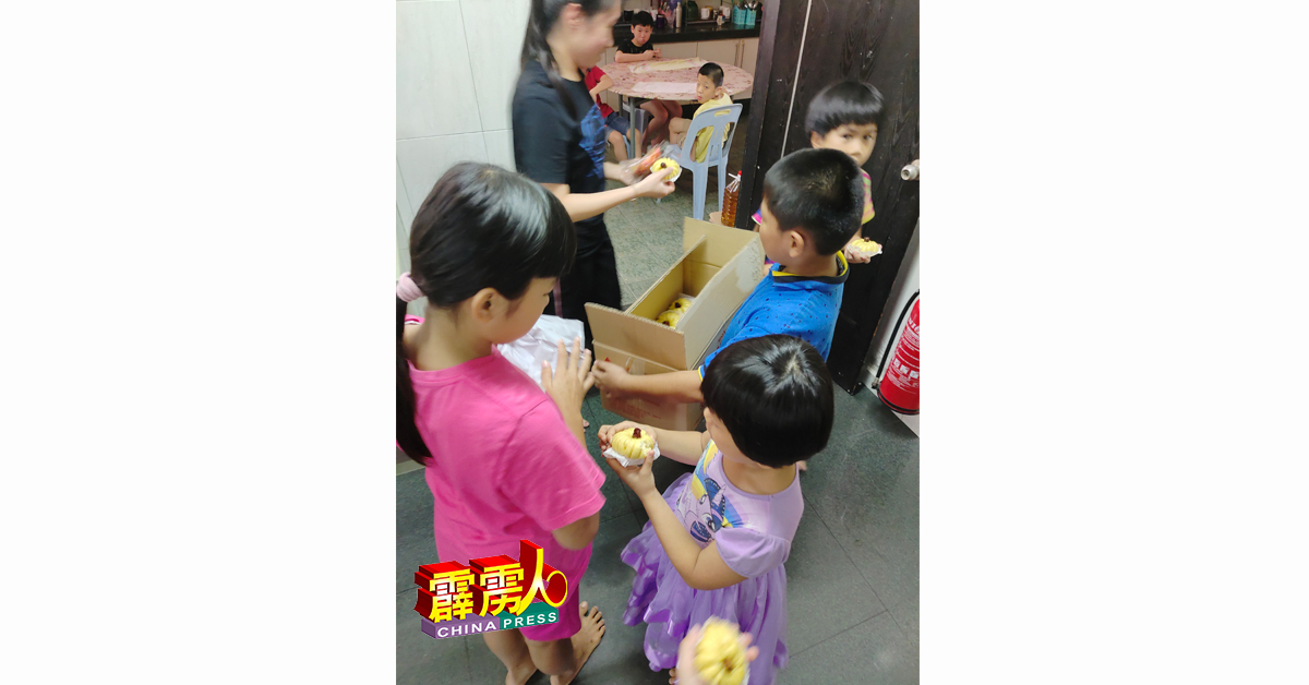 桂寰婧（左）率领弟妹们，将小蛋糕分发给安顺杰护幼之家的家庭成员享用。