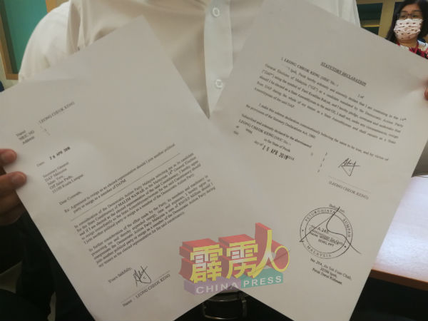 张宇晨向媒体展示梁卓经曾签署的法定声明（右）及同意书（左）。