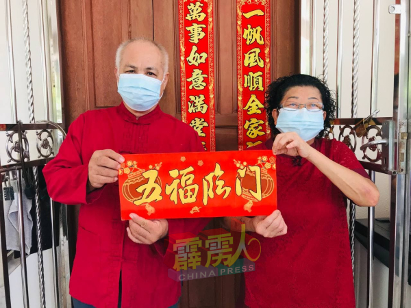 麦成与郭玉环夫妇特地着上红彤彤的红衣，向《中国报》读者道声“新年好”！