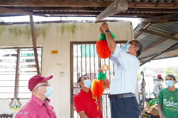 鲁迈兹（右2）为华裔家庭挂上新年吊饰。