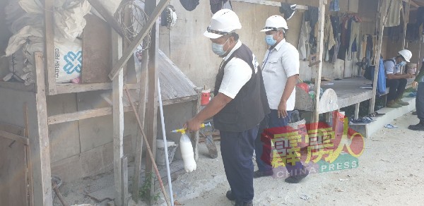 卫生局官员在工地宿舍喷射蚊油，以防蚊子滋生。
