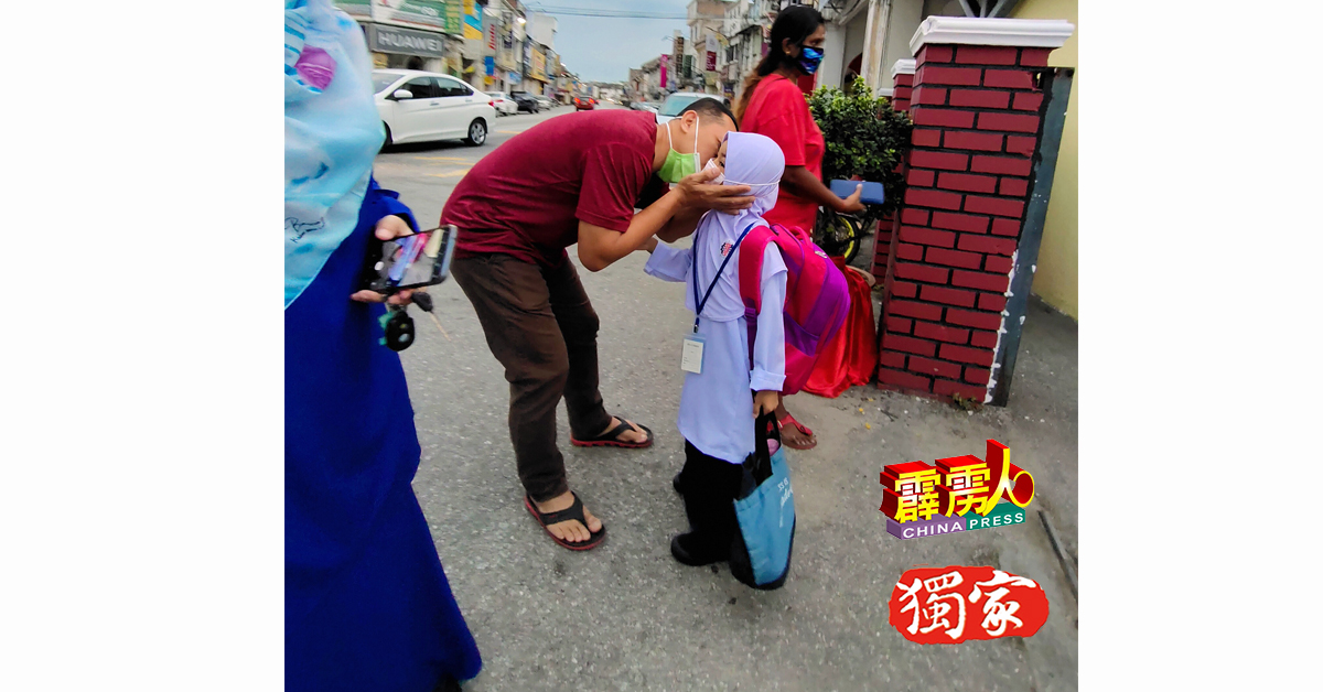“女儿啊，愿你开学日顺顺利利。”一名马来父亲，在校门口亲吻女儿脸颊，为她献上祝福。