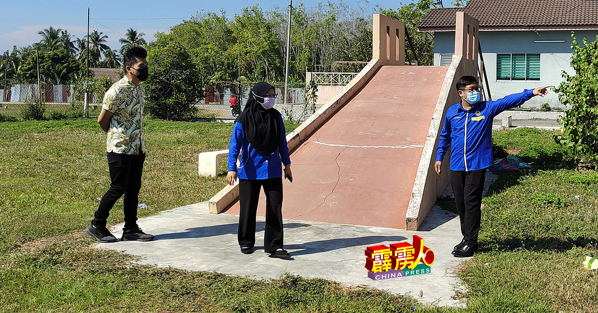 蔡长华（右）与邓洧康（左）在胡姬花园，研究儿童游乐场年久失修问题。