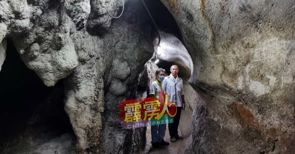 刘锦华（右）与黄金喜步入狭小的洞穴，途经之处的低层石壁是由屈德福所打通的通道。