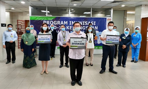 苏建祥（中）与黄诗情（第二排左起）及张哲敏，在金宝诊所接受新冠肺炎疫苗接种。