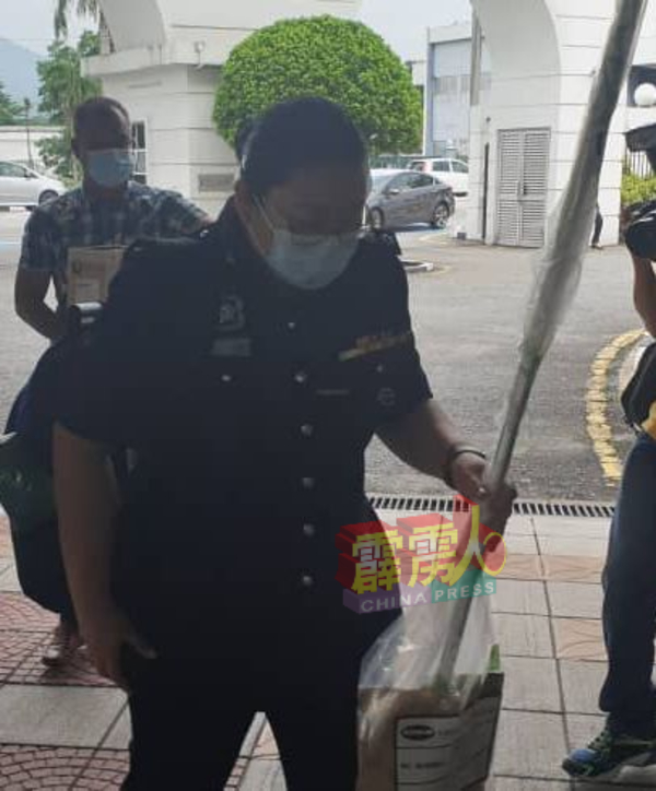 查案警官叶秀菁助理警监，在同僚陪同下，持扫把及其他证物抵达高庭。