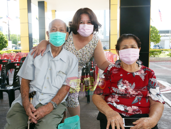 温彩玉（中）特地从吉隆坡回来，陪同父母温木清（左）及黄兰娇（右）接受疫苗接种。