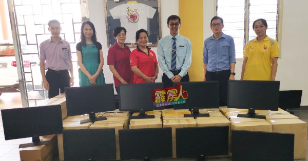 万华一校教师黄燕燕（左2）陪同姐姐黄渼仪（左4起），移交捐赠的30台桌面型电脑给校长陈志明代表接领。