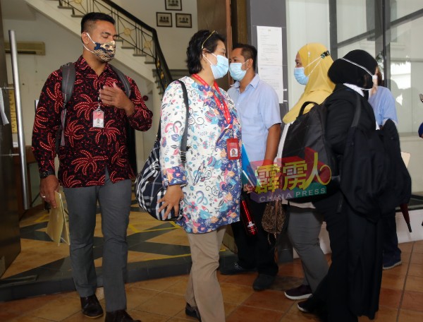 来自印尼大使馆的力奇沙巴里（左1）在宣布休庭后，步出法庭。
