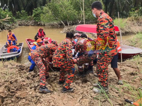 参与搜救行动的消拯员合力将死者遗体抬上岸。