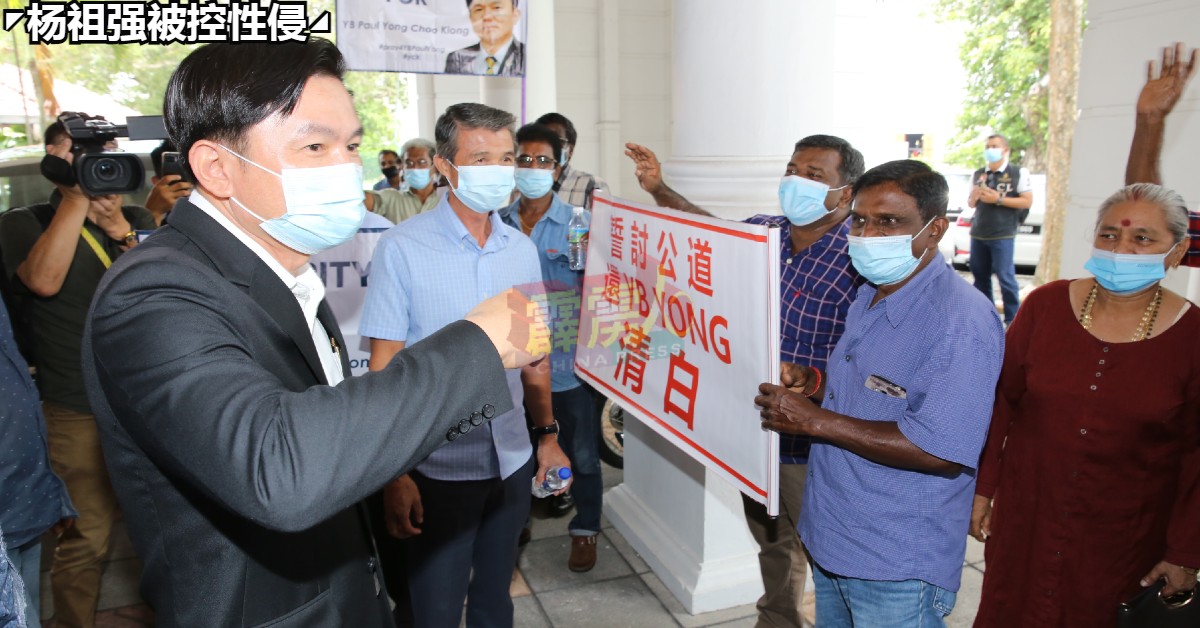 杨祖强（左）中午休庭步出法庭时，向在场声援的支持者致谢。