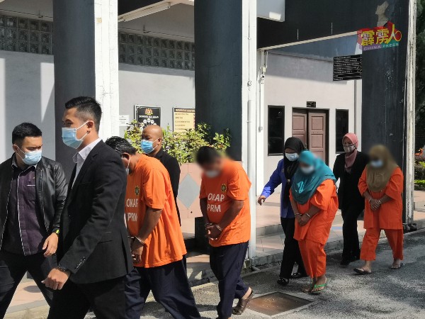 身穿橙色囚衣的男女嫌犯，被带往法庭申请延扣。