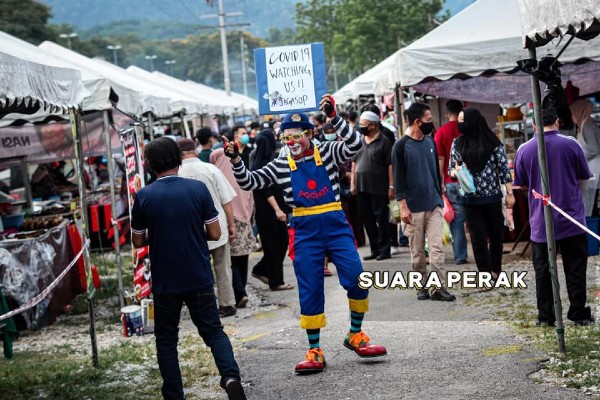 小丑走在人来人往的市集中显得格外令人瞩目。 （图取自Suara Perak）