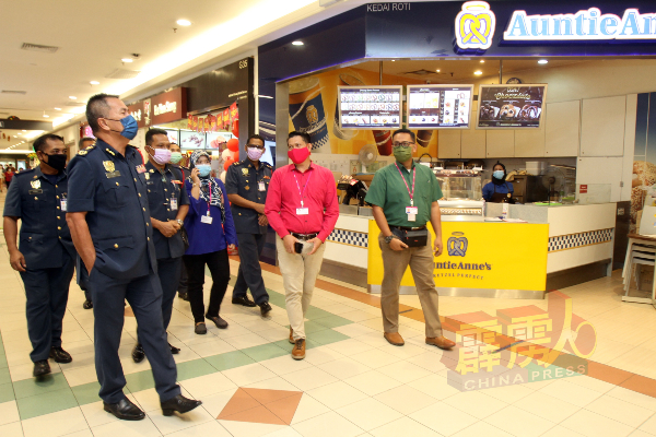 阿兹米（左）与属下人员抵达购物中心巡视消防设施，并听取负责人峇都尔（右2）汇报。