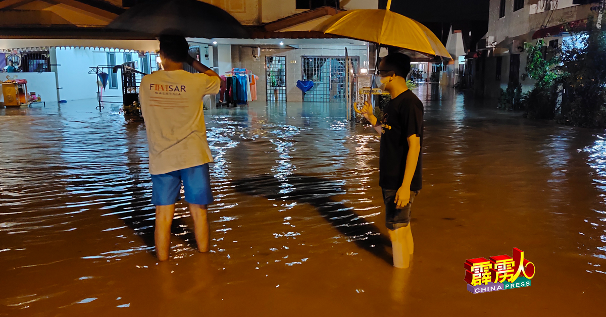 和丰在劳动节夜晚爆发严重水患，吴锡华撑伞涉水进入灾区，了解情况。