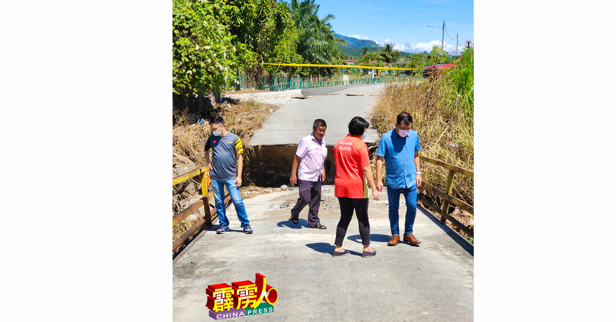 罗思义（右）与友人，了解林玛斑让通往亲善村桥樑崩塌的情况。
