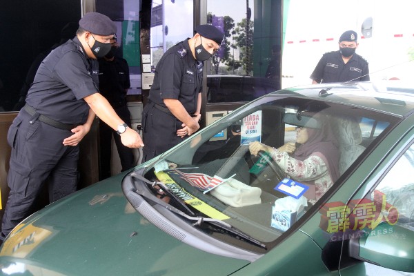 米奥法立（右2起）在阿斯马迪陪同下，检查路过的车辆，确保驾车人士遵守标准作业程序。